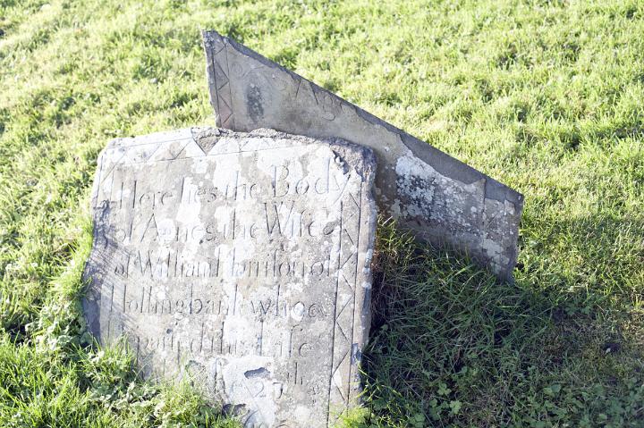 Close up Old Broken Tombstone on Grassy Graveyard. Captured on a Sunny Climate.