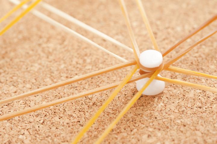 Networking Node Concept - Close up White Pin with Rubber bands on Brown Cork Board