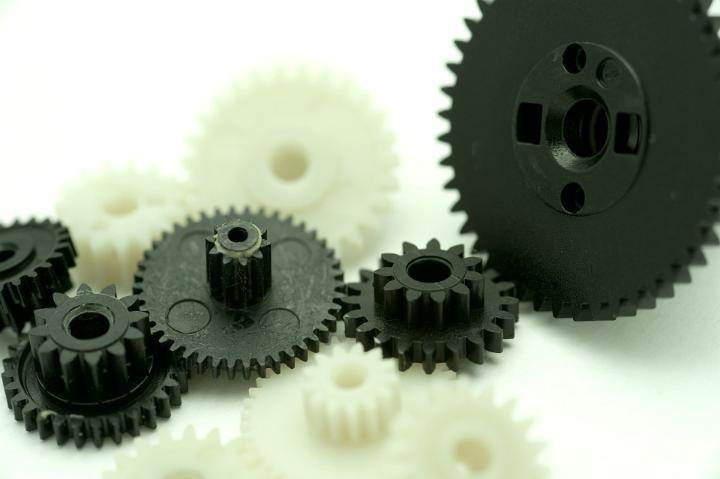 Close up Assorted Sizes of Plastic Black and White Gear Wheels on White Background, Emphasizing Teamwork Concept