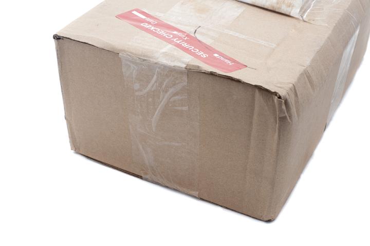 Close up Brown Postage Box with Tape on White Background, Emphasizing Copy Space.