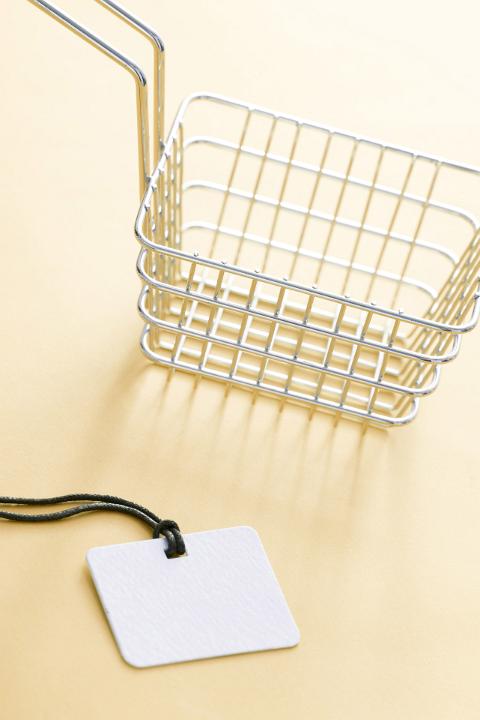 New metal kitchen deep fryer with blank white price tag on a pale yellow background