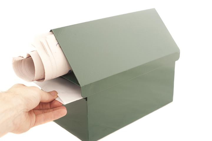 Conceptual Human Hand Pulling a Mail From the Box. Isolated on White Background. Emphasizing Copy Space.