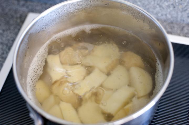 Peeled and Chopped Potatoes Boiling in Pot of Hot Water on Stove Top as part of Meal Preparation