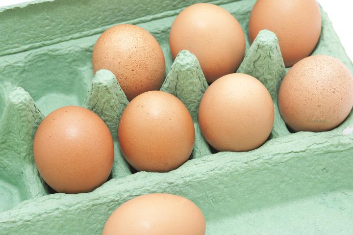 Fresh brown hens eggs in a cardboard carton retail packaging , high angle view of the open box