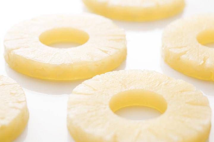 Fresh, yellow pineapple slices isolated on a bright white background with copy space.