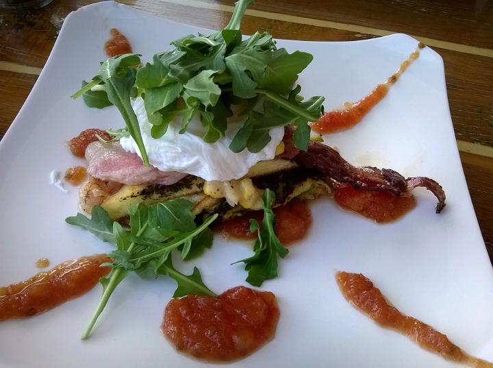 A gourmet restaurant breakfast dish of poached eggs with a healthy green garnish of rocket leaves.