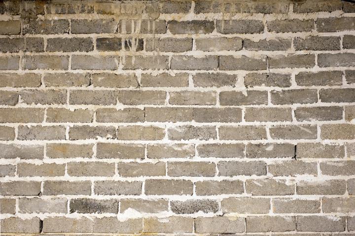 Old brick wall background texture and pattern with grunge mortar between exterior face bricks in an architectural or construction material concept