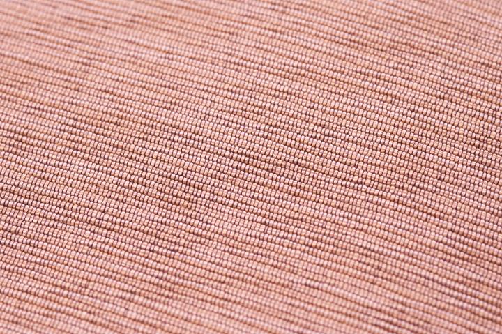 Close Up Detail of Woven Pink Fabric Showing Texture Suitable for Backgrounds and Copy