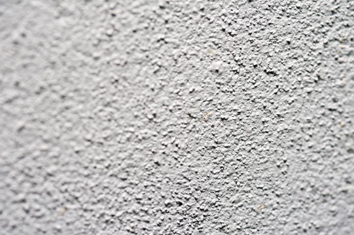 Rendered white wall background texture with a rough stippled surface to the plaster, full frame with center focus