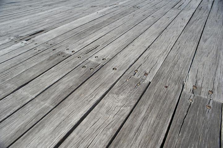 Background texture and pattern of old weathered wooden decking with a low angle receding perspective