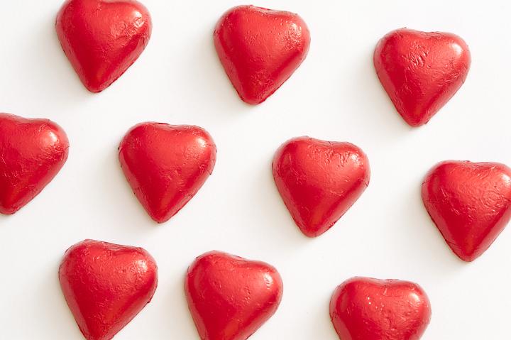 Red chocolate valentine hearts in a pattern arrangement isolated on a white background with copy space.