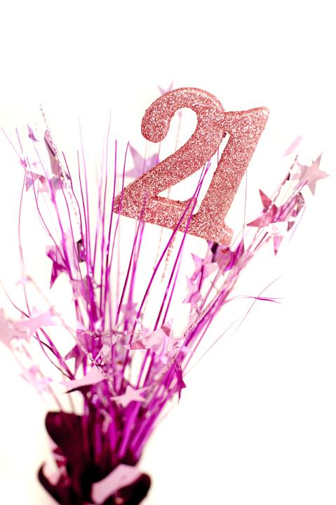 21st birthday celebration for a girl with a display of pink decorations with the glitter numbers surrounded by stars over a white background