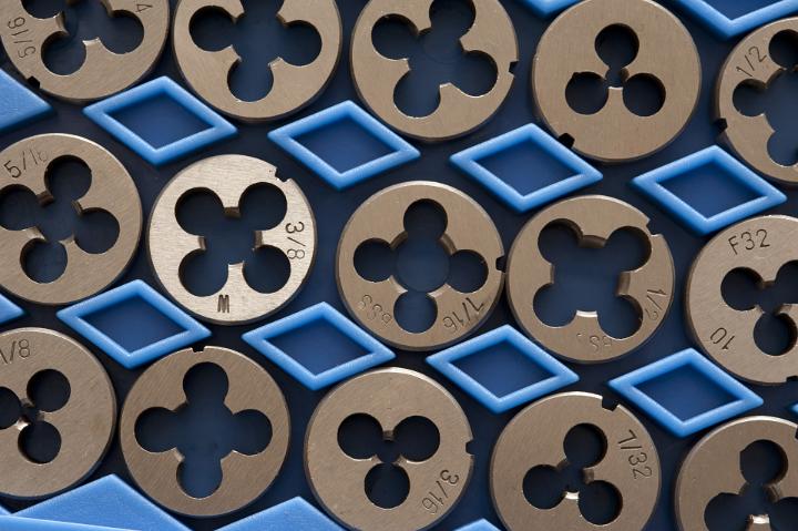 Set of packaged engineering dies for cutting the threads on a screw, close up overhead view