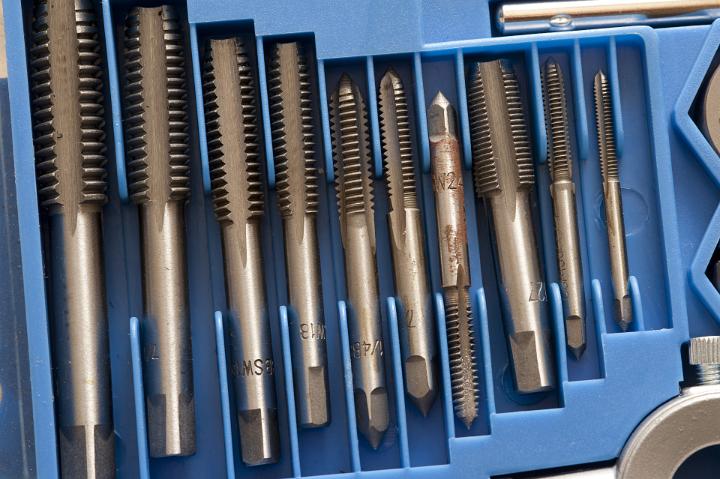 Set of engineering taps for turning and cutting threads on screws in blue fitted commercial packaging