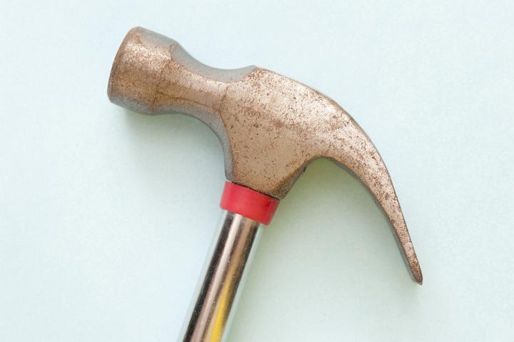 Side view of the head of a claw hammer on a white background in a woodworking, construction and DIY concept