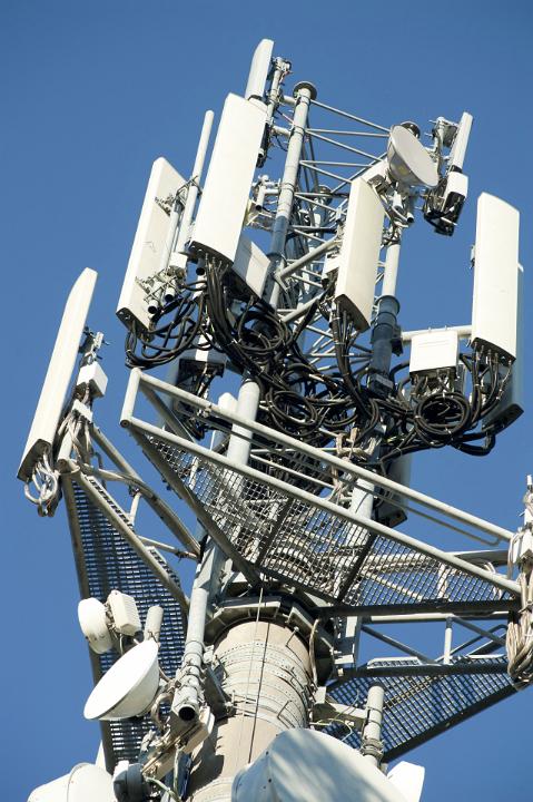 Low Angle View of Telephone Communications Tower with Satellites and Radar Against Blue Sky