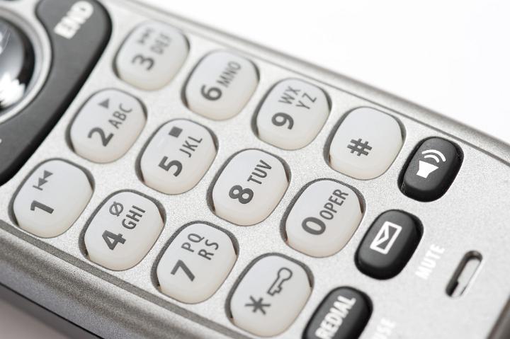 Close up of the alphanumeric keypad and function buttons on a telephone handset in a communications concept