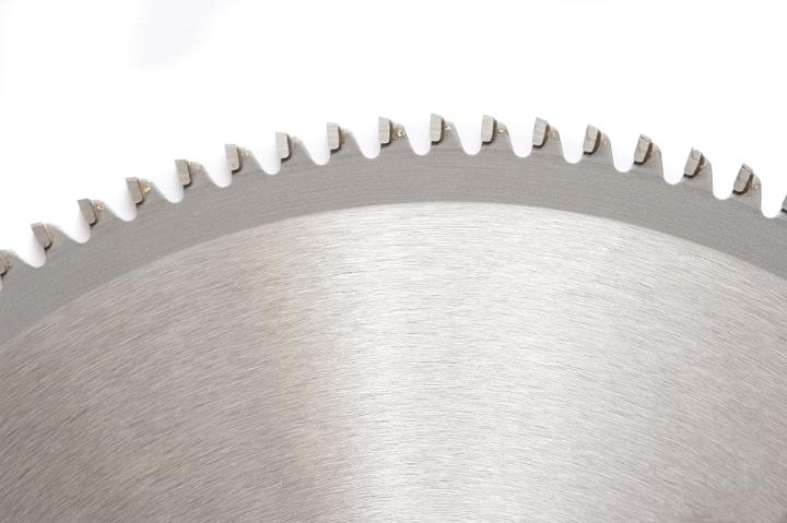 Part of wood saw teeth in close-up isolated against white background