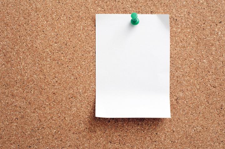 Close up Blank White Note Paper Pinned on Brown Cork Board, Emphasizing Copy Space.