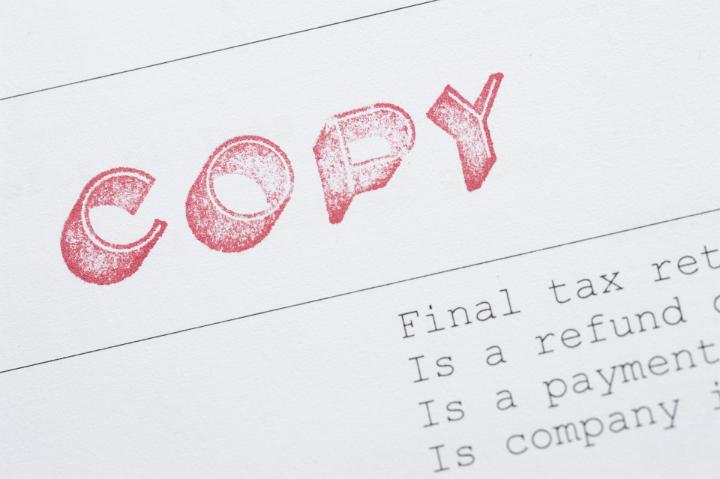 Close up Shot of Conceptual White Copy of Final Tax Return Document with Red Label.