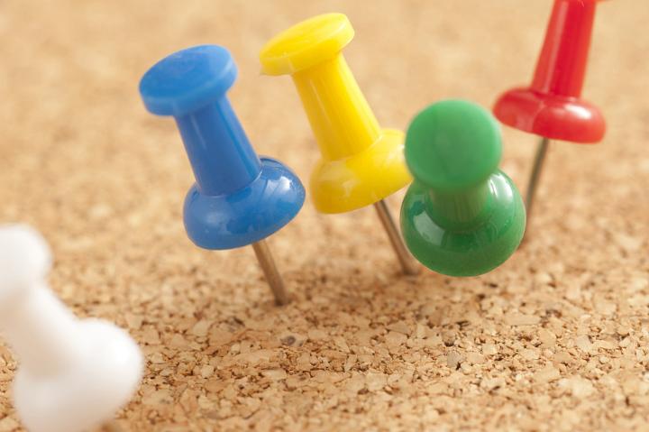Close up Shot of Conceptual Assorted Colored Pins on Brown Cork Board