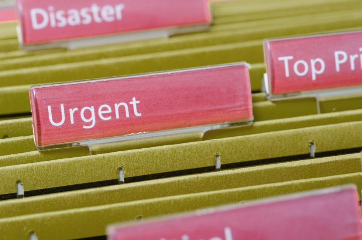 Urgent Concept - Close up Files in Yellow Folders with Urgent Text on a Pink Label