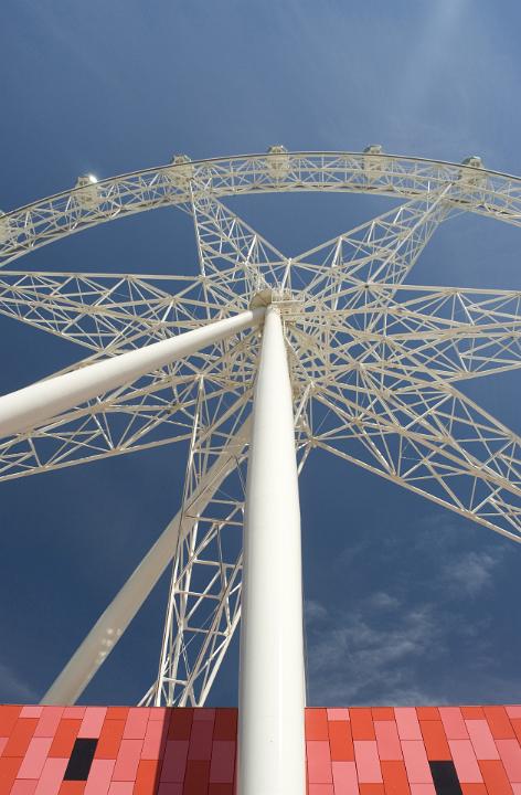 Ferris wheel viewed from directly below showing the supporting structure and passenger gondolas suspended high in the air on a fairground or at a carnival