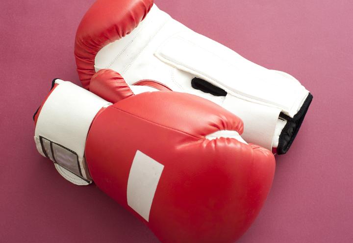Close up Pair of Red White Sports Boxing Gloves for Fitness Activity on Dark Pink Background