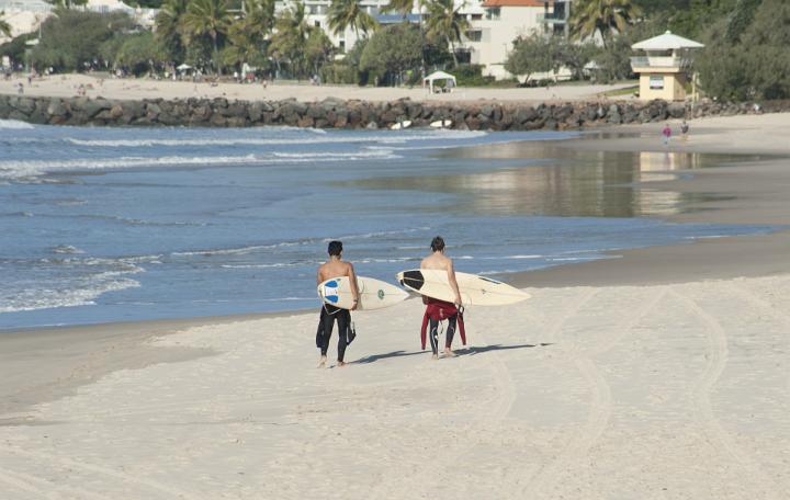 Two Male Surfers Holding Surf Boards having a Vacation at the Beach on a Tropical Climate.