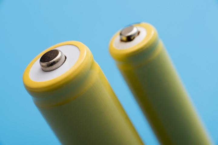 Close-up of two battery cells against blue background