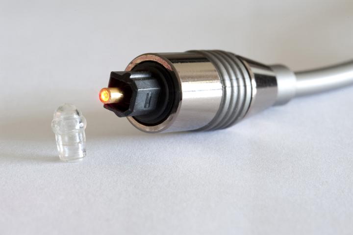 Close Up Still Life of Glowing Fiber Optic Connector Cable in Studio with White Background