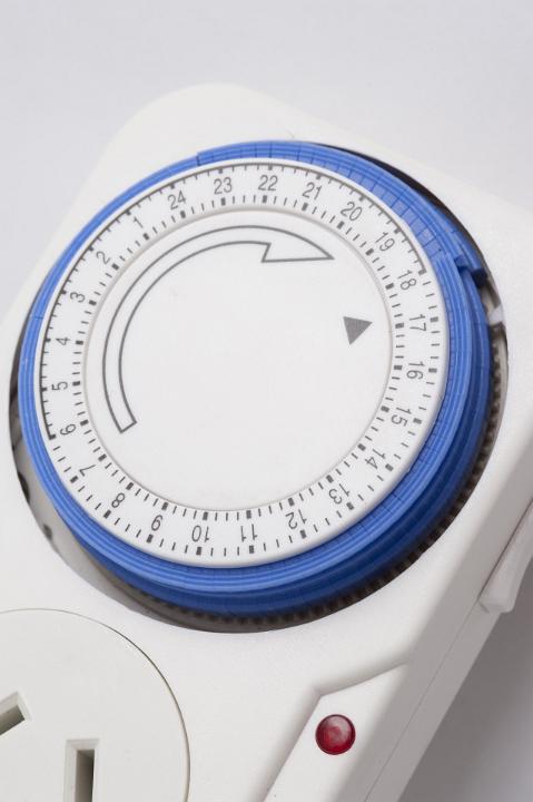 Close up of the dial and control of a plug in timer to regulate the switch off and on time on an electrical device over a 24 hour period