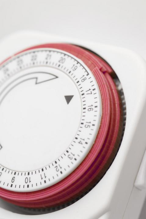 Close Up Still Life of Analog Timer with Red Dial on White Background, Time Concept Image
