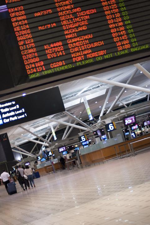 Angled Interior of Uncrowded Airport Terminal with Arrivals and Departures Board and Rows of Numbered Service Desks