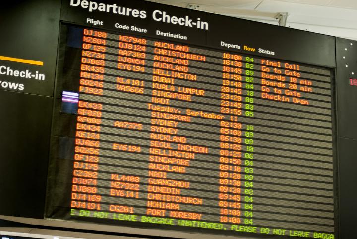 Flight information at the check-in for departures at an airport terminal with a board listing all flight information in a travel concept