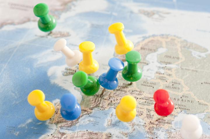 Close Up of Multiple Colorful Pins Inserted into Map of Europe in International Travel or Business Planning Concept